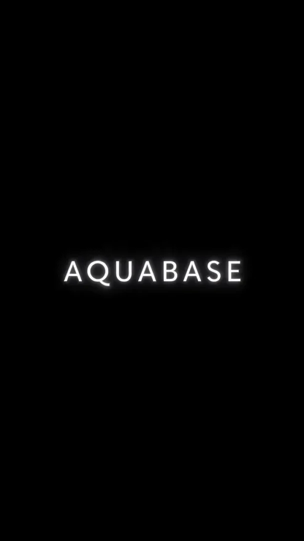 暗転した画面の中央にAQUABASEという商品名のテロップが白く光って表示されている縦型のAI生成動画